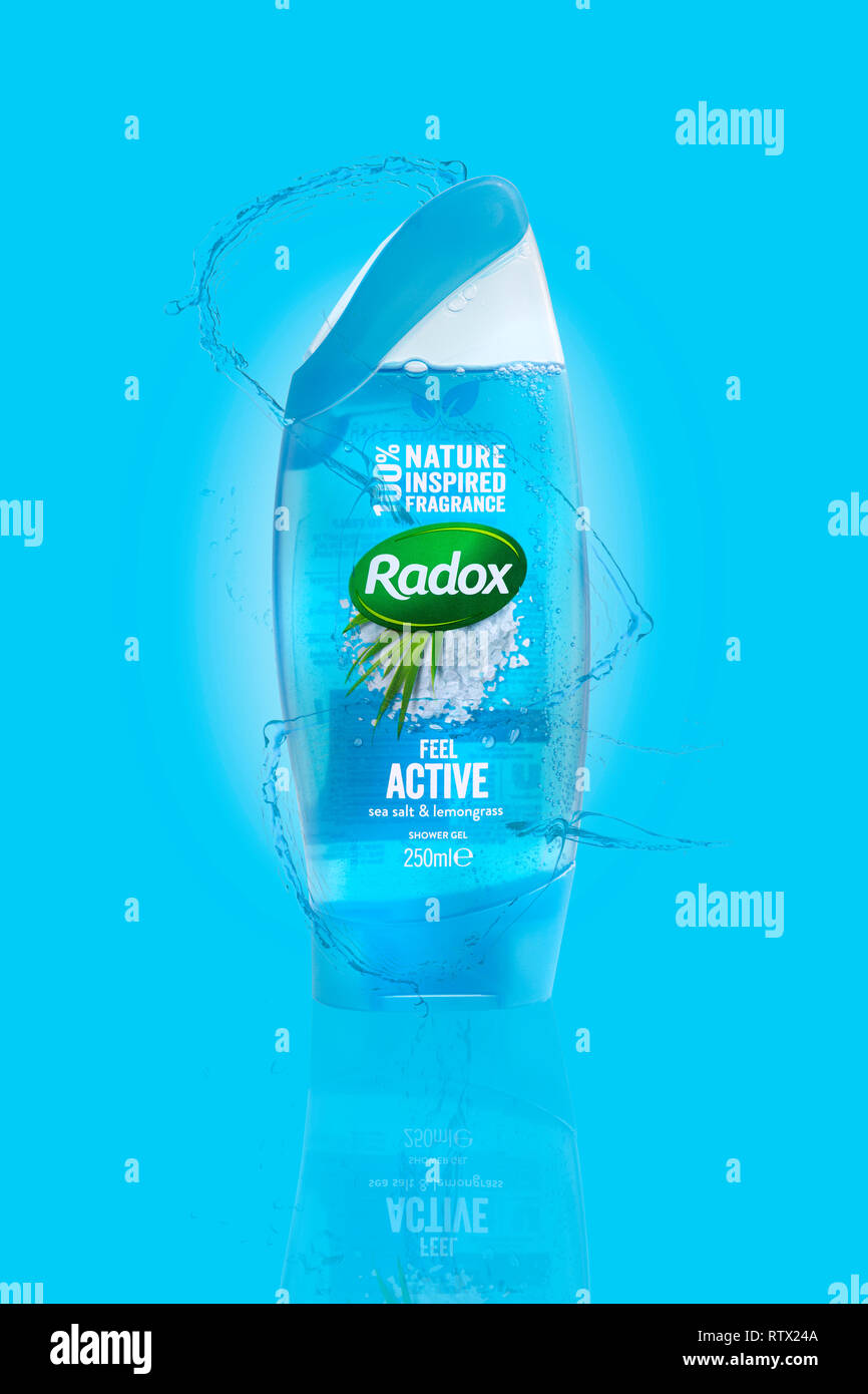 SWINDON, Regno Unito - 3 Marzo 2019: Radox sale marino e la citronella Gel doccia su una luce blu e l'acqua spruzzata sullo sfondo Foto Stock