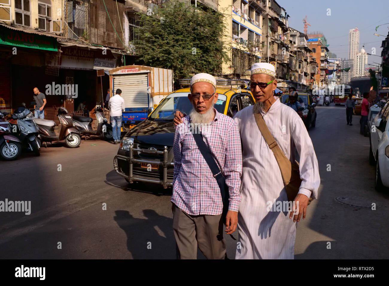 Due amici appartenenti al moderato (musulmano) Bohra comunità di Mumbai a piedi una strada nel musulmano-dominato Pydhonie area, Mumbai, India Foto Stock