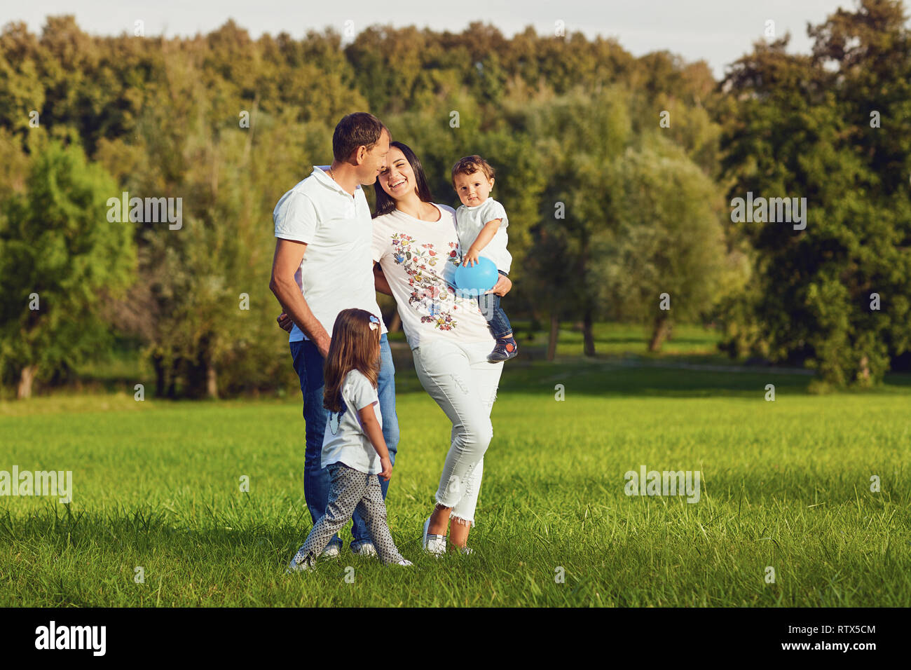 La famiglia felice con bambini sono a piedi nel parco. Foto Stock