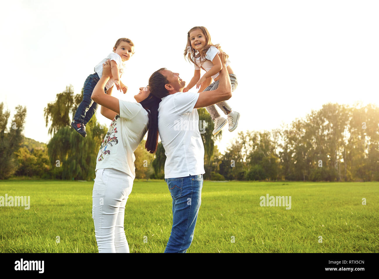 La famiglia felice con i bambini nel parco. Foto Stock