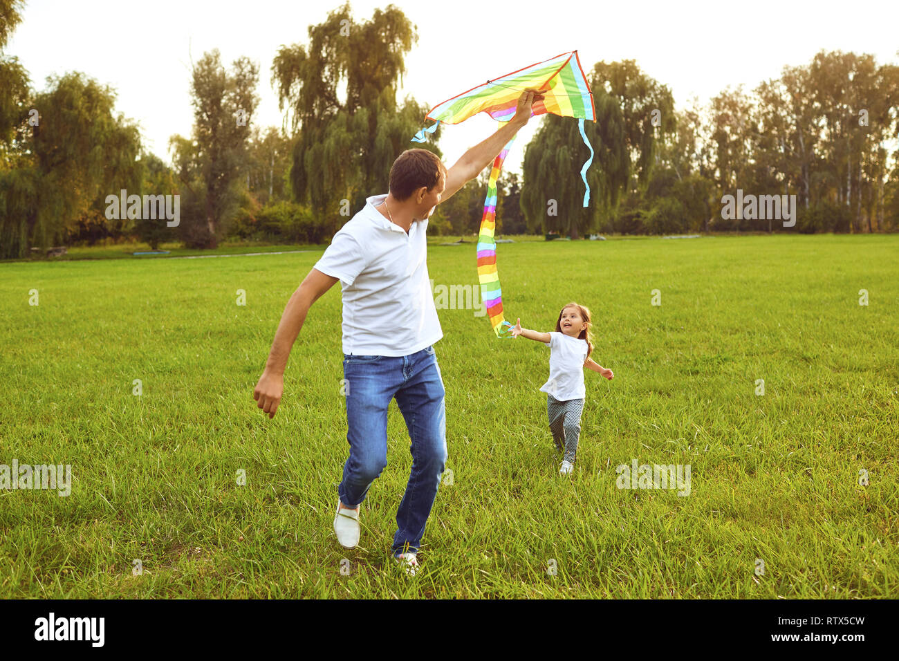 La famiglia felice padre e figlio eseguire sul prato con un aquilone in estate la natura Foto Stock