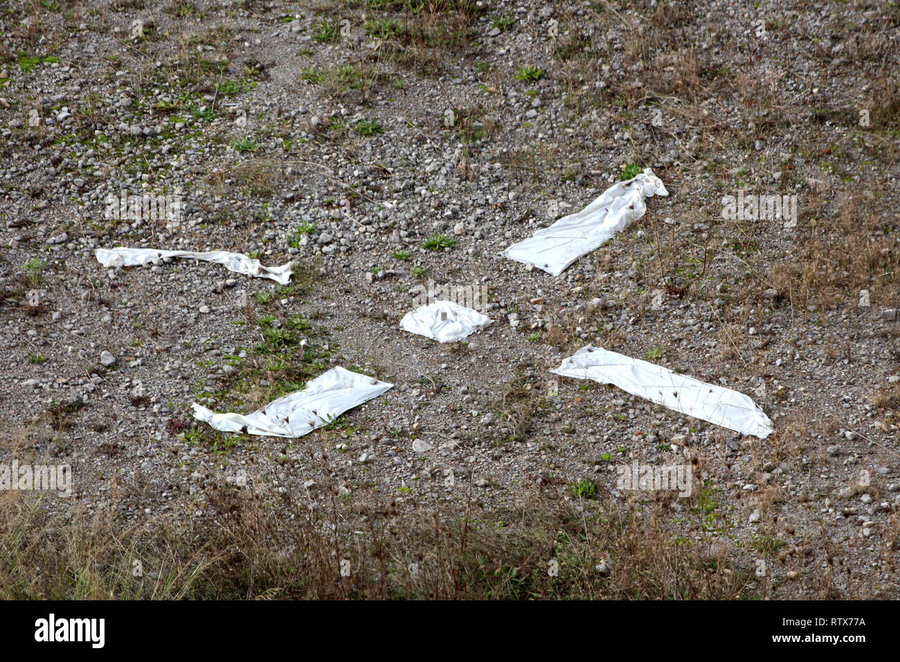 X segna il punto improvvisato punto di atterraggio per mostrare i paracadutisti realizzato con nylon bianco sulla ghiaia circondata con erba secca sulla calda giornata di sole Foto Stock