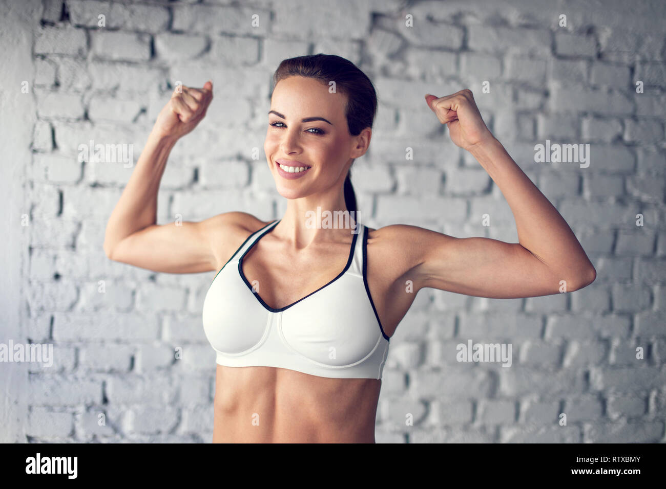 Montare la giovane donna che mostra bicepses ritratto Foto Stock