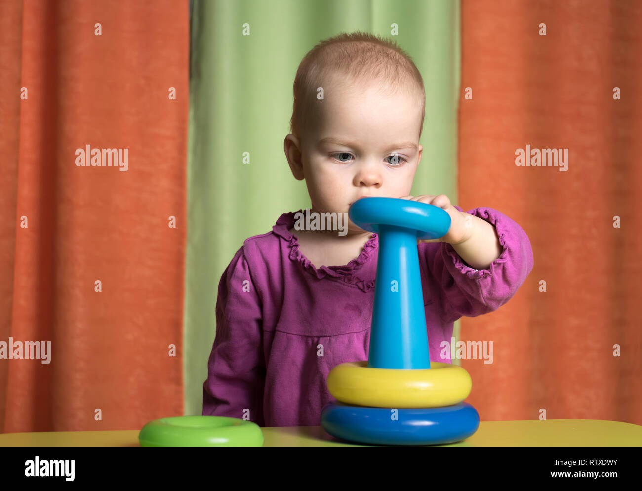Il kid raccoglie una piramide, l'ingombro di un anello di colore blu Foto Stock