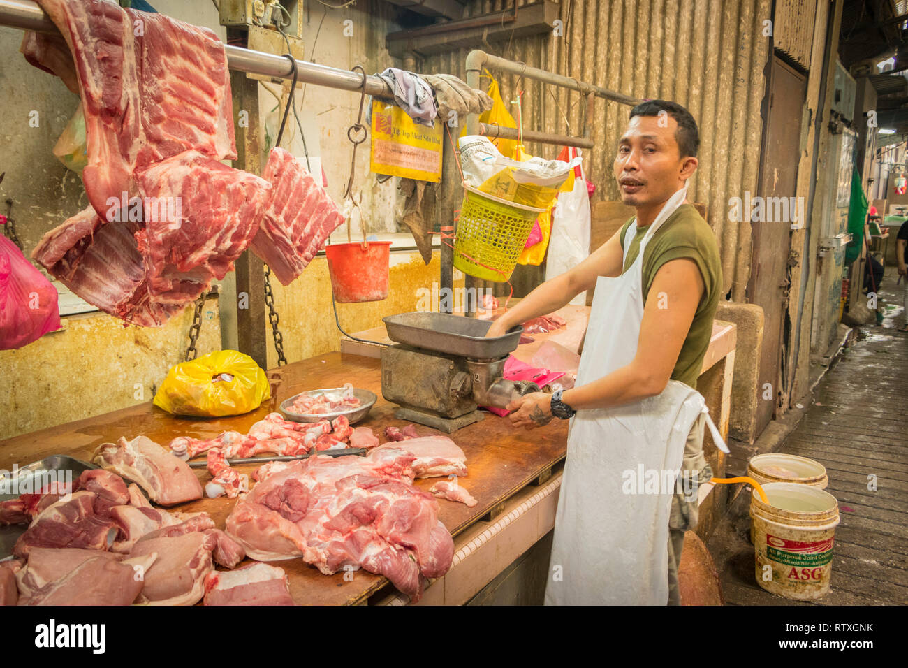 Butcher macinazione di carne sul mercato in stallo Chinatown di Kuala Lumpur in Malesia Foto Stock
