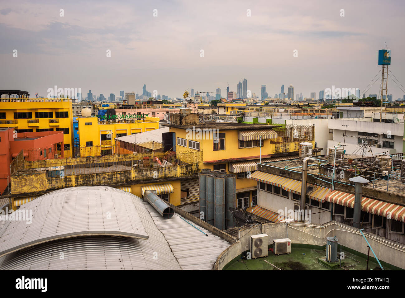 Tetti della vecchia Bangkok con il moderno skyline di Bangkok in background Foto Stock