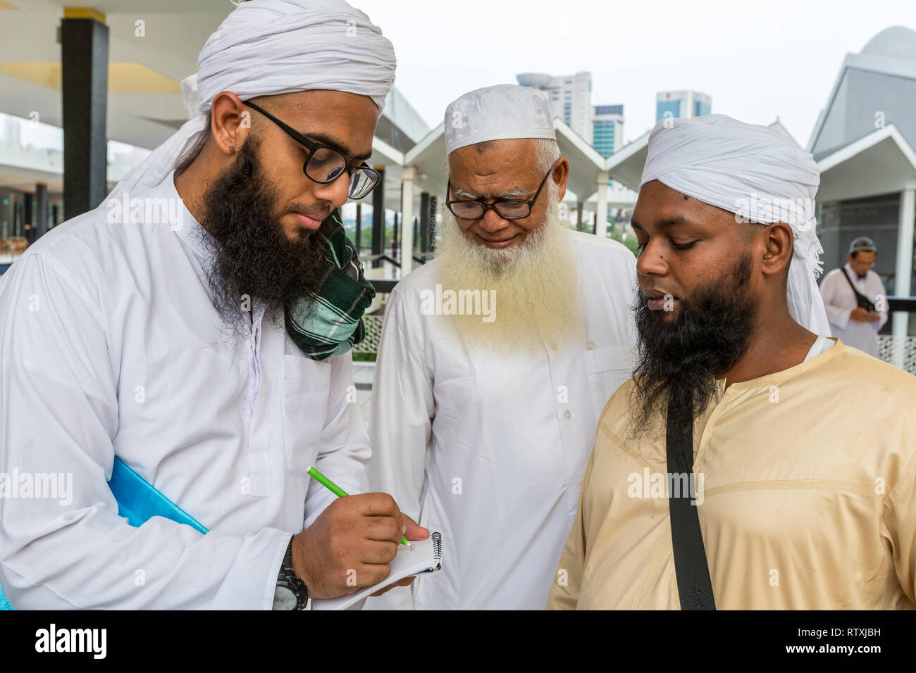 Musulmana del Bangladesh in visita la Masjid Negara (Moschea nazionale) di Kuala Lumpur in Malesia, la scrittura di indirizzo di posta elettronica per il fotografo. Foto Stock