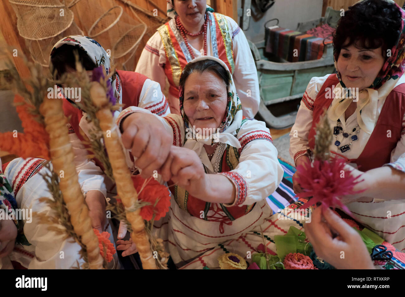 Donne bielorusse in abito tradizionale decorare un matrimonio tradizionale pane durante la rievocazione di un tradizionale matrimonio bielorusso all'interno del Motal Folk Arts Museum di Motol o Motal una township di Ivanava Raion della regione di Brest Foto Stock
