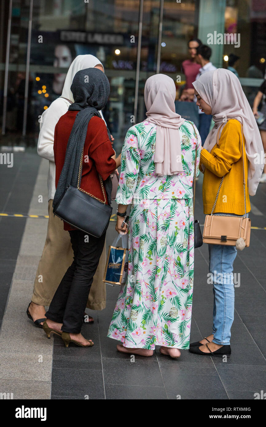 Donne malesi indossando il tradizionale e moderna occidentale in stile casual abbigliamento, Pavilion Mall, Kuala Lumpur, Malesia. Foto Stock
