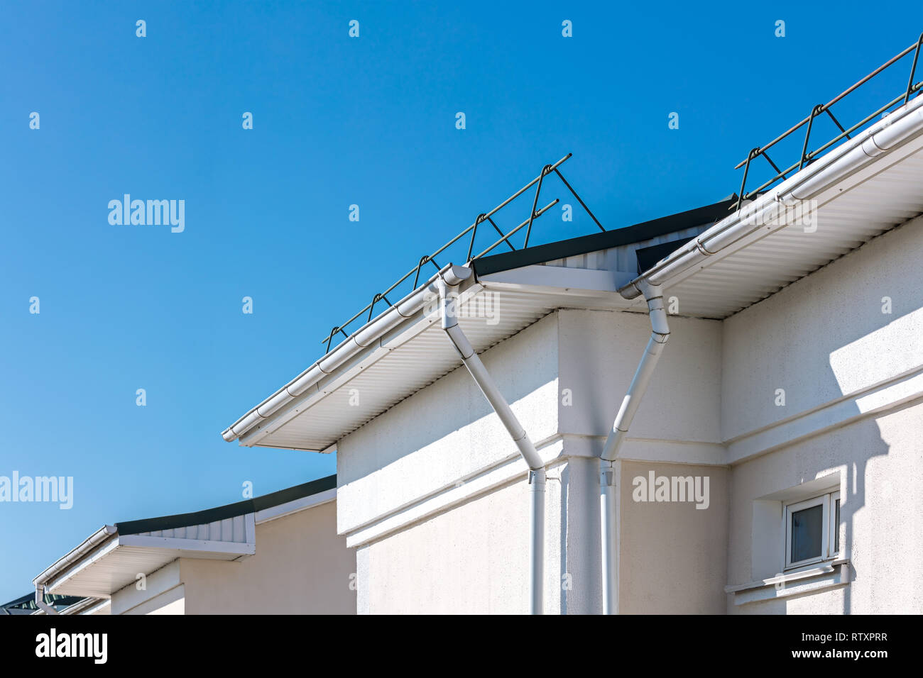 Pioggia di gronda e sistema di protezione del tetto da snow board. rinnovato roof contro il cielo blu sullo sfondo Foto Stock