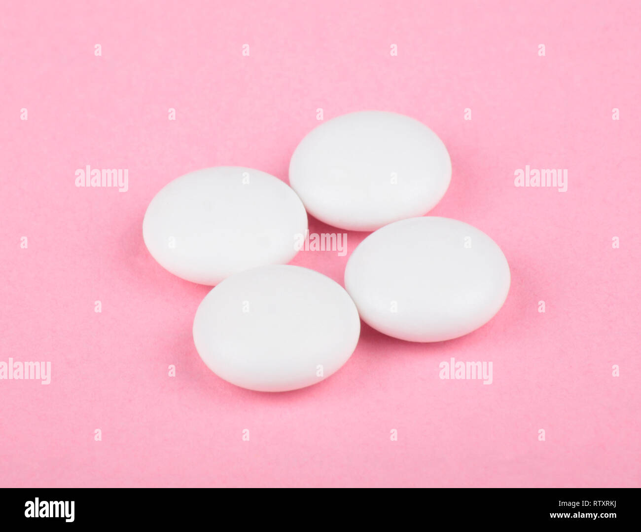 Pillola bianco su sfondo rosa Foto Stock
