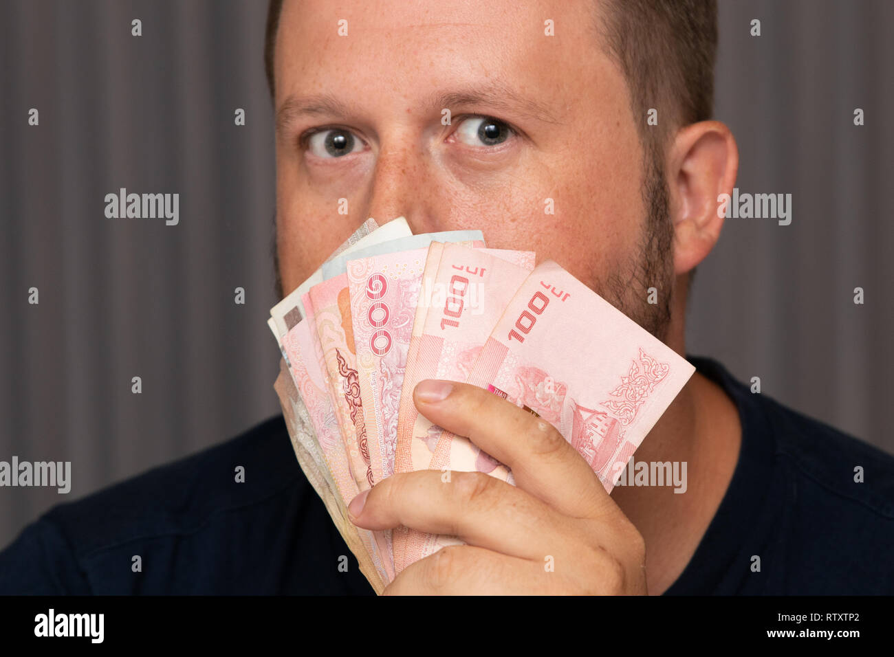 Imprenditore mano afferrando il denaro, Thai Baht. per il trasferimento di denaro Foto Stock