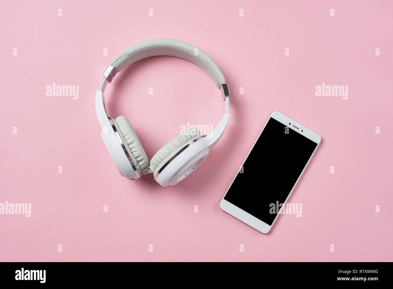 Bianco cuffie wireless dello smartphone e pastello su sfondo rosa Foto Stock