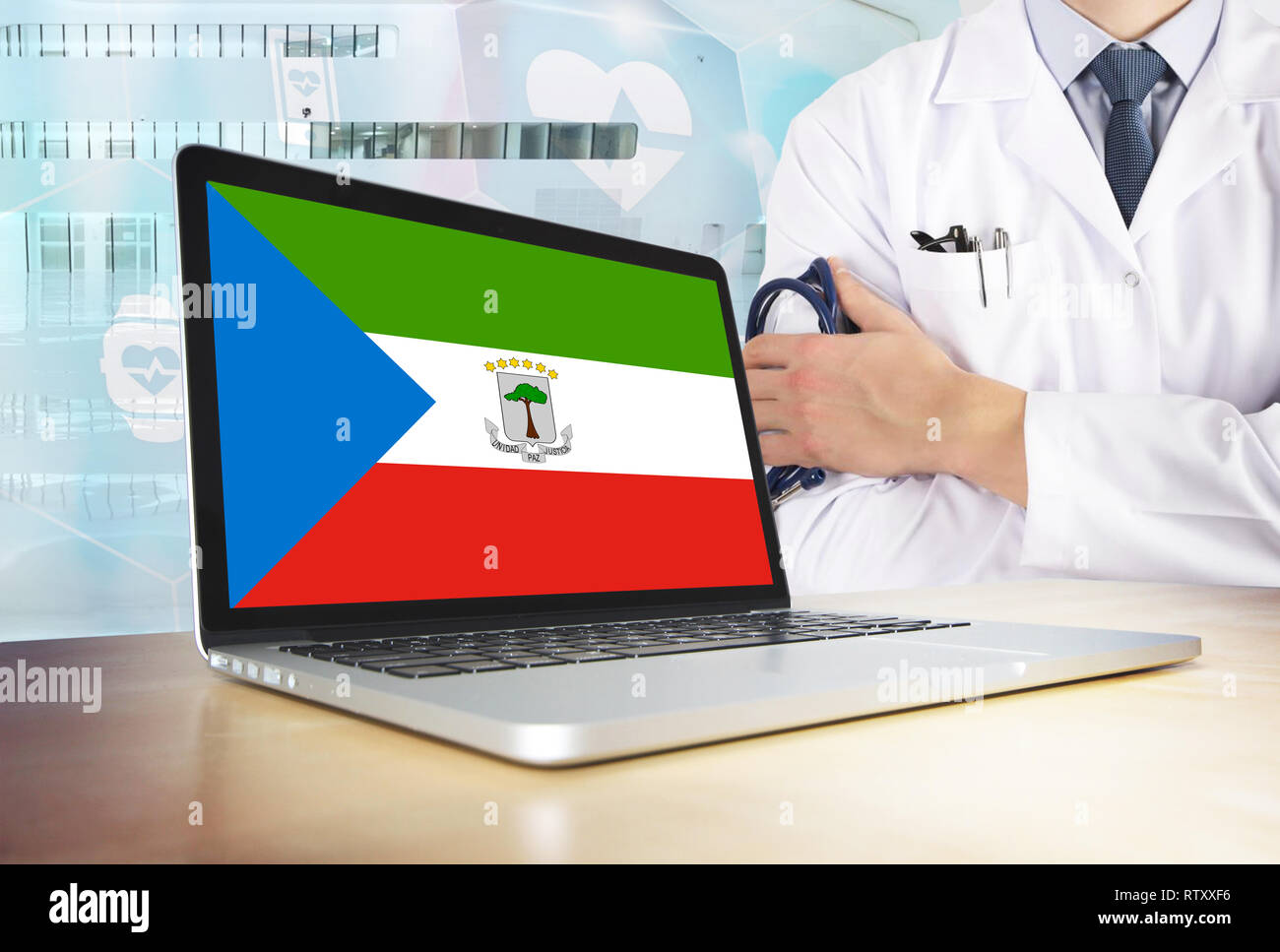 Guinea equatoriale sistema sanitario in tech theme.Bandiera sullo schermo del computer. Dottore in piedi con uno stetoscopio in ospedale. E Cryptocurrency Blockchain Foto Stock