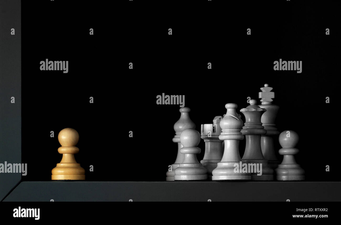 un pedone è isolato da altri pezzi di scacchi bianchi che affrontano la discriminazione nella società Foto Stock