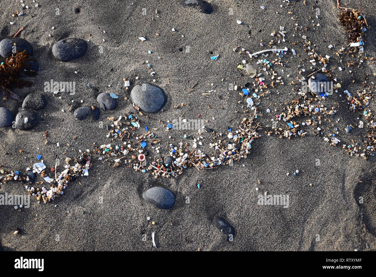 Le piccole parti in plastica e microplastics nella sabbia della spiaggia di Famara, Lanzarote, Spagna. Foto Stock