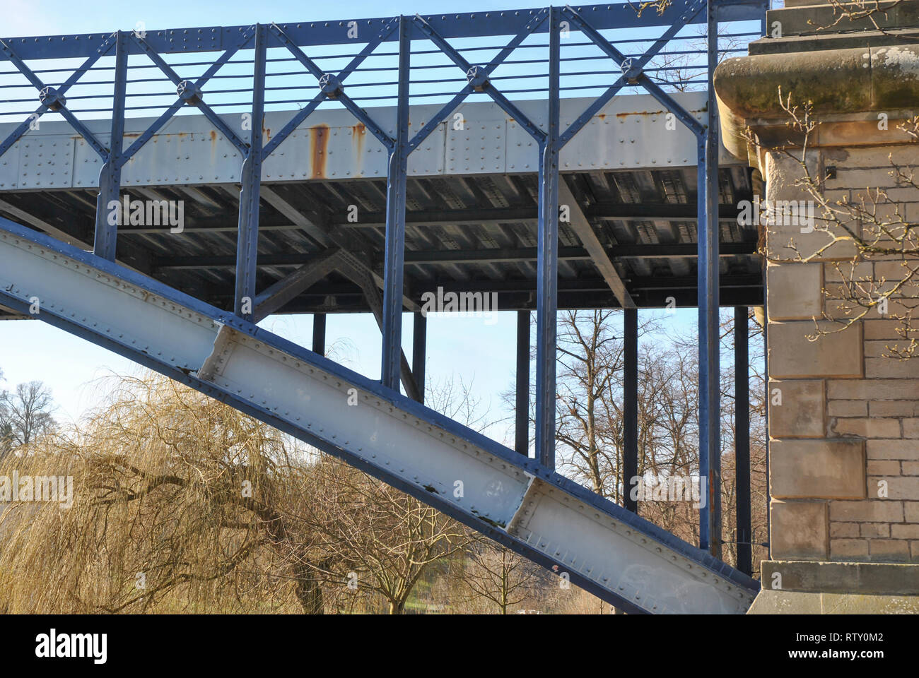 Un metallo vecchio ponte sul fiume che mostra il lavoro della pietra e tralicciati lavori in metallo Foto Stock