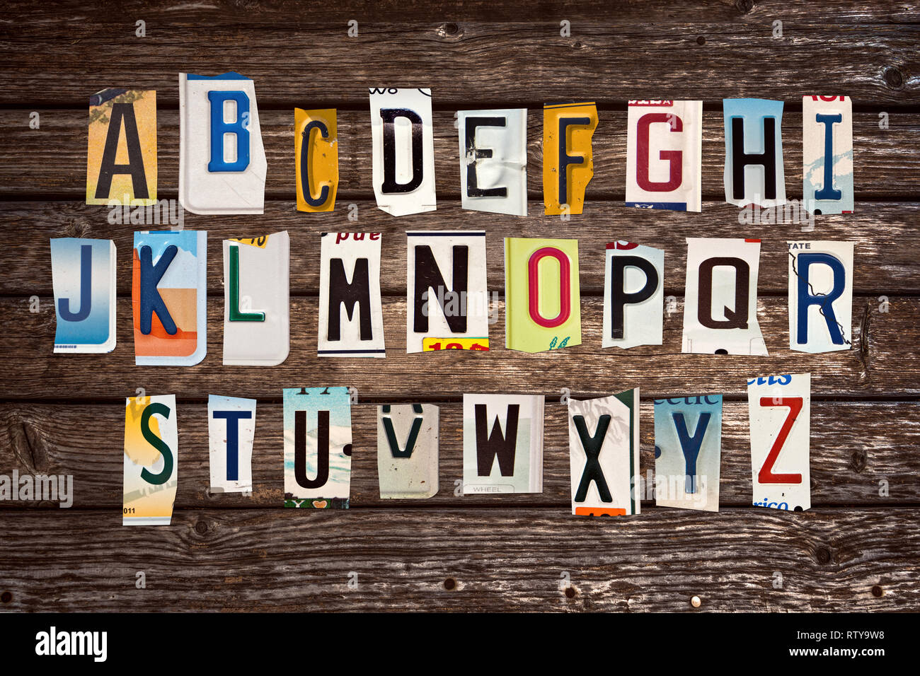 Alfabeto creato con pezzi rotti di auto d'epoca, targhe su tavole di legno sfondo Foto Stock
