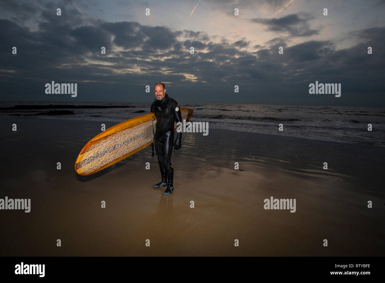 Surfer, riempire in Flash, crepuscolo, Compton Beach, Isle of Wight, England, Regno Unito Foto Stock