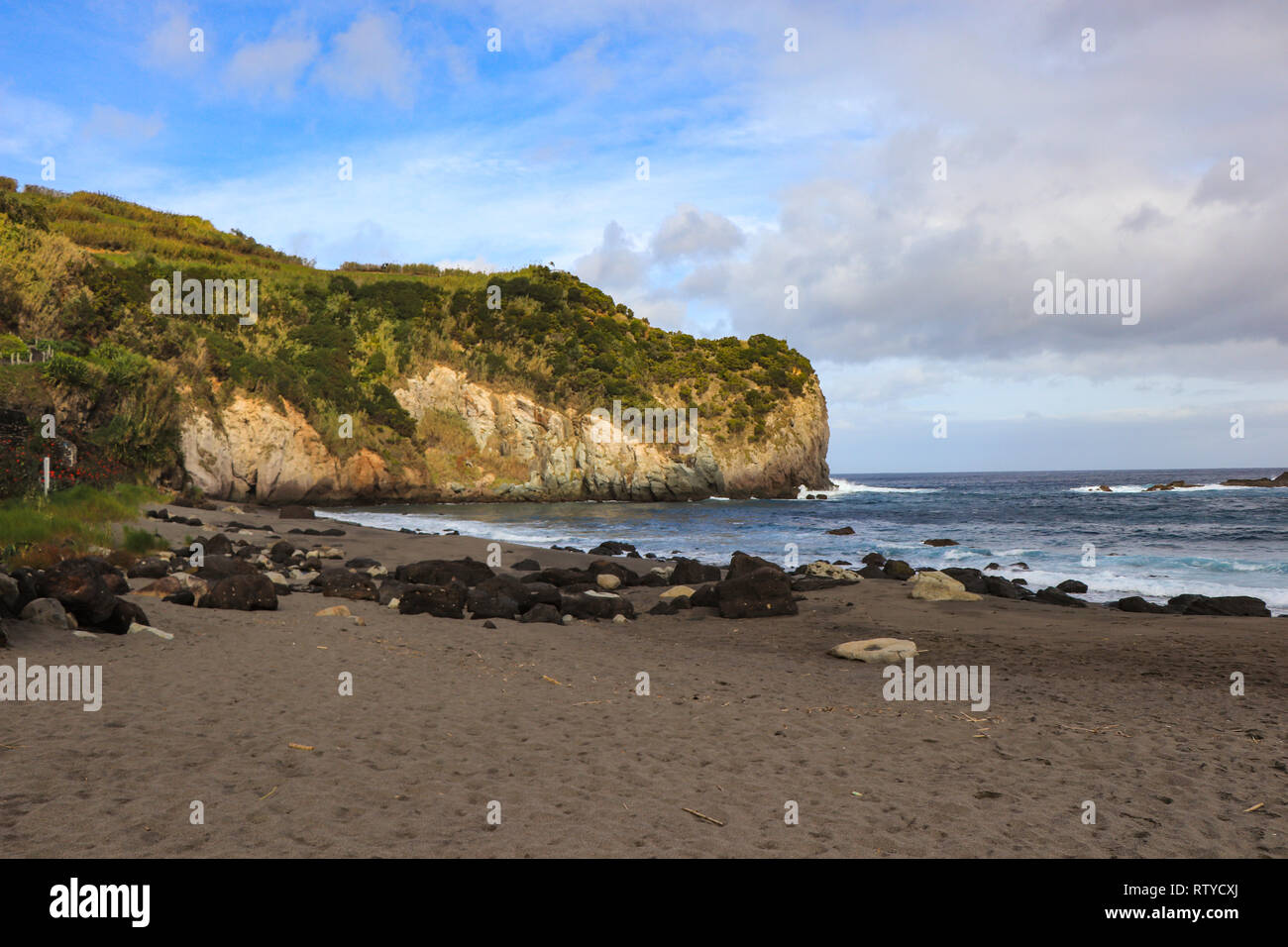 Spiaggia con sabbia nera vulcanica con acqua del mare turchese. Seascape nella fascia costiera del Portogallo. Isole Azzorre. Foto Stock