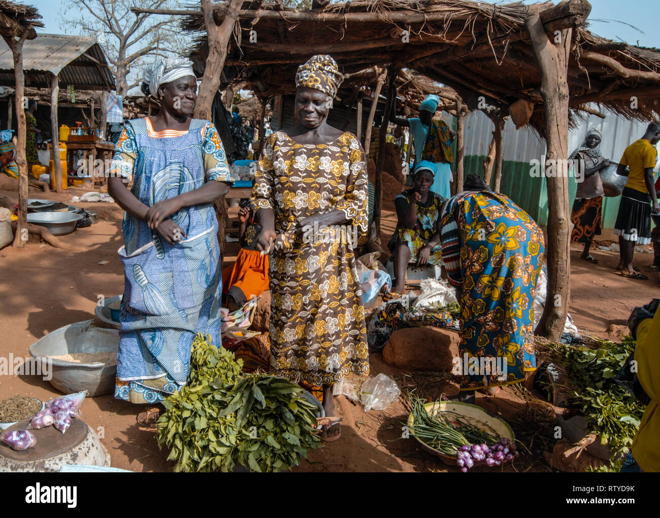 Una bella foto di due bellissime donne ghanesi che indossa gli abiti tradizionali vendono spezie e verdure presso il locale mercato fresco in Kongo village. Foto Stock