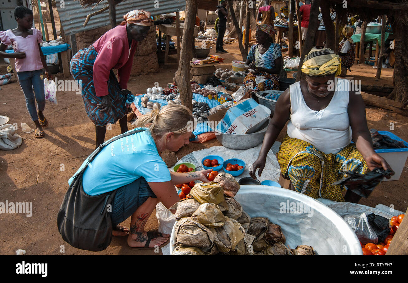 Un turista acquistando alcune verdure locali presso un mercato agricolo in Kongo village, Ghana, Africa occidentale Foto Stock