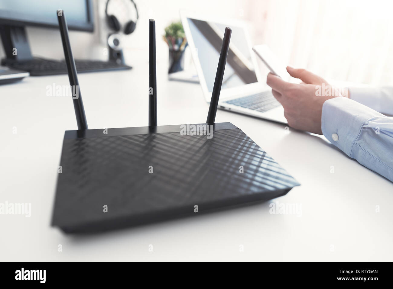 Router Wireless concetto. L'uomo utilizza lo smartphone in background Foto Stock
