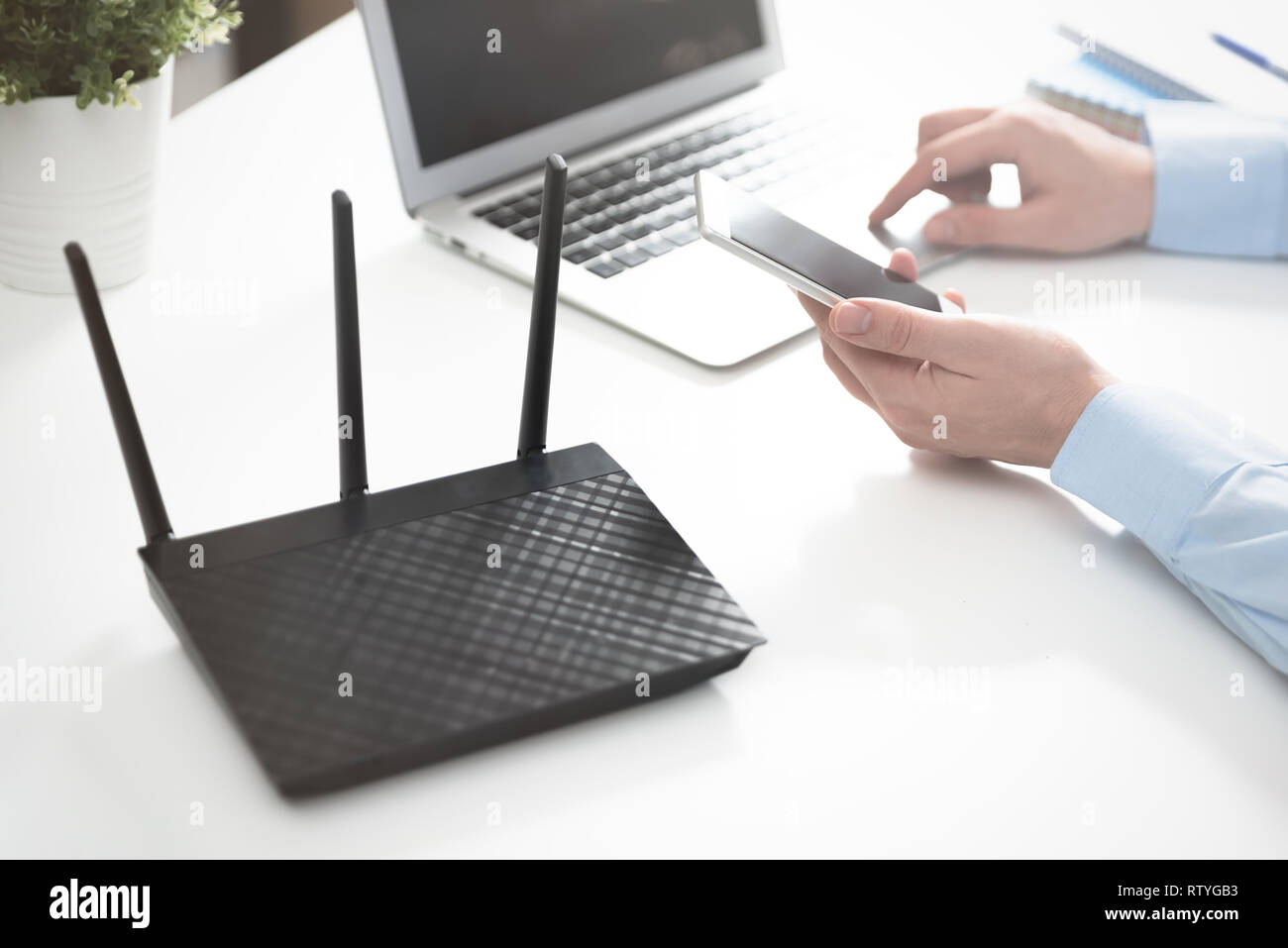 Router wireless o access point. L'uomo utilizza lo smartphone Foto Stock