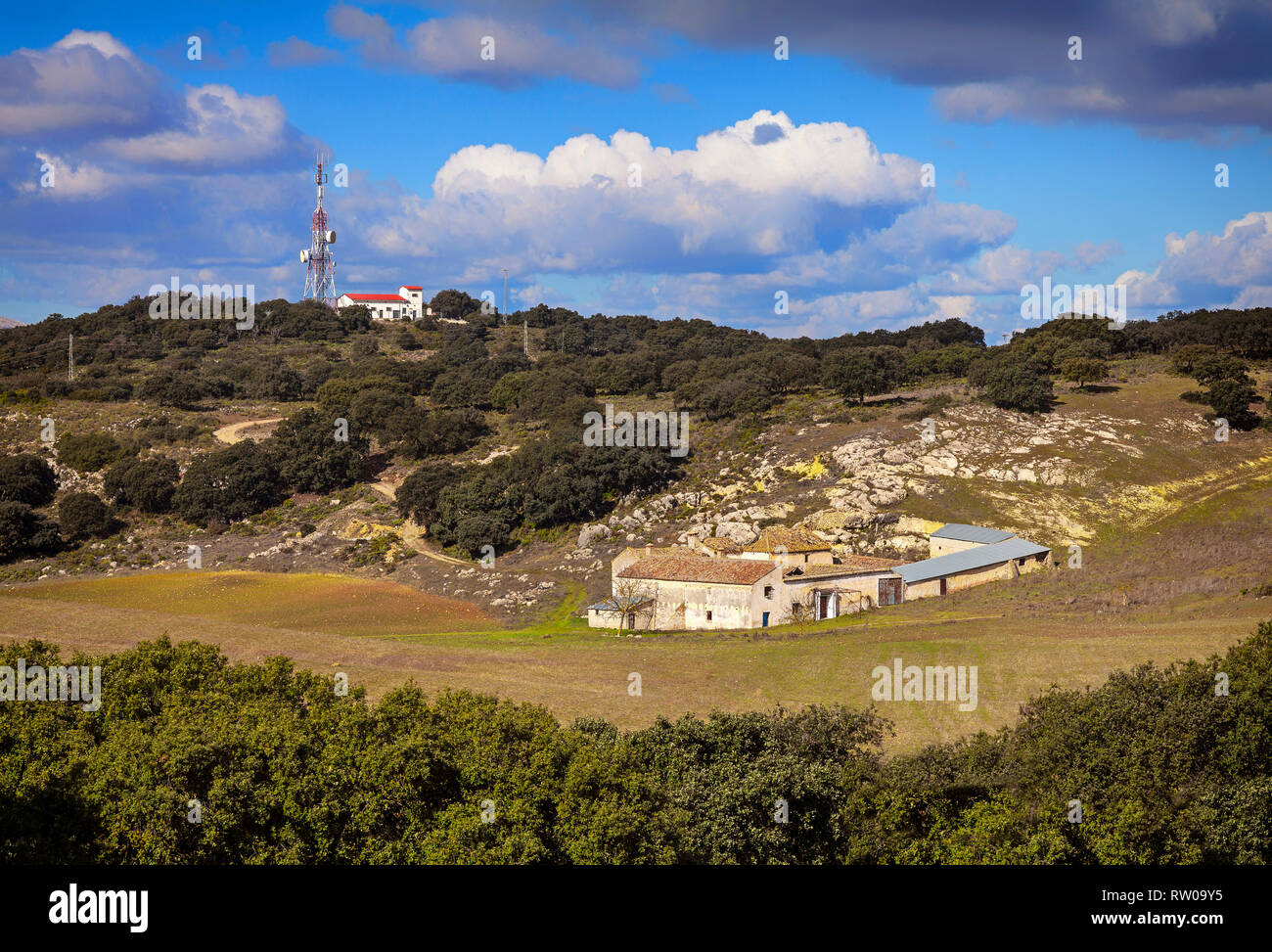 Un montante di comunicazioni torri al di sopra di una spalmatura, ma deserte o agriturismo Casa de Campo, con i campi coltivati nella parte anteriore. Provincia di Granada, Spagna Foto Stock