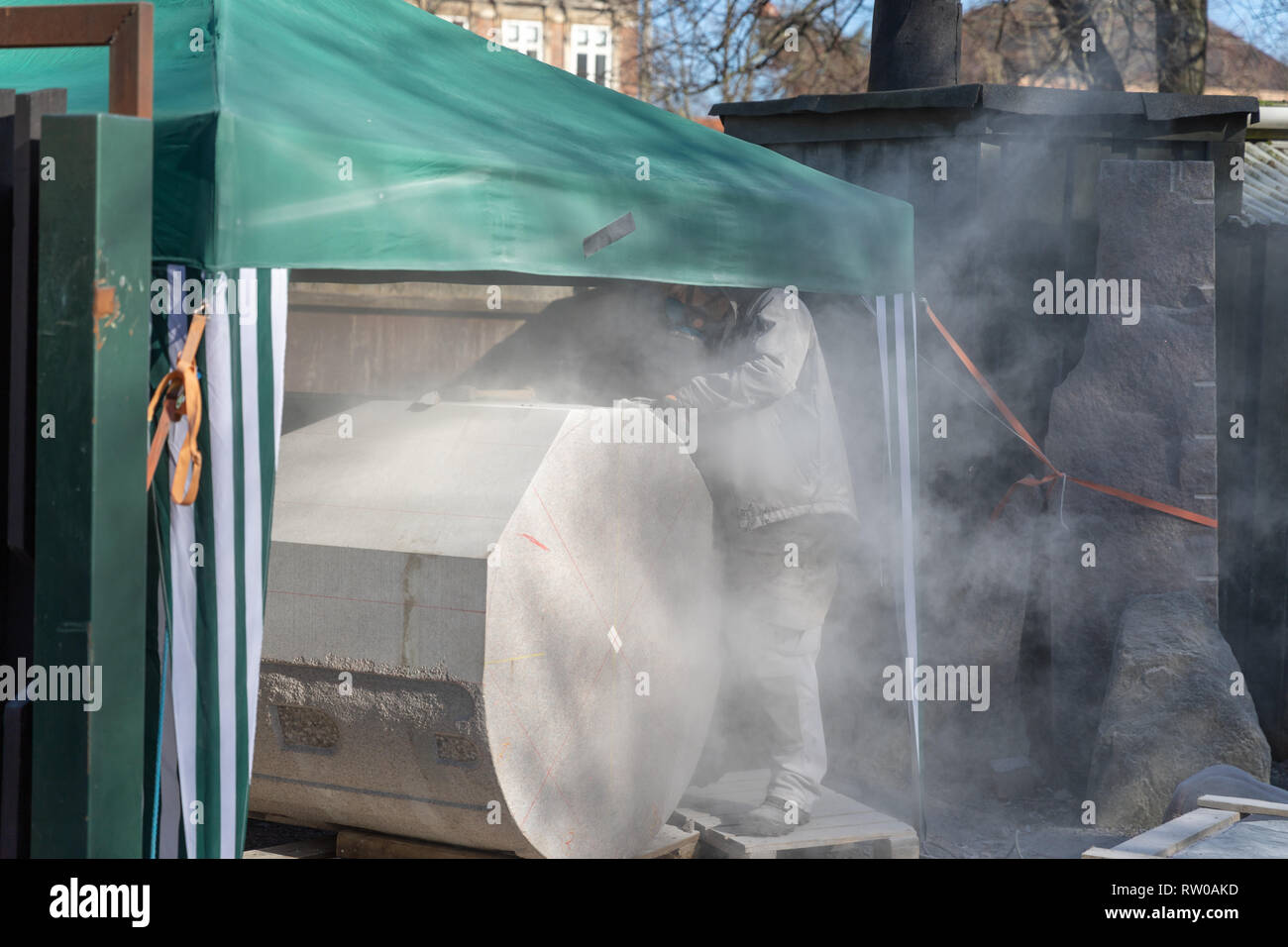 Muratura monumentale; mason macinazione di una pietra con una smerigliatrice angolare Foto Stock