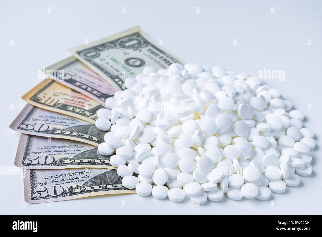 Grande pila di pillole di bianco seduto su una le fatture del dollaro Foto Stock