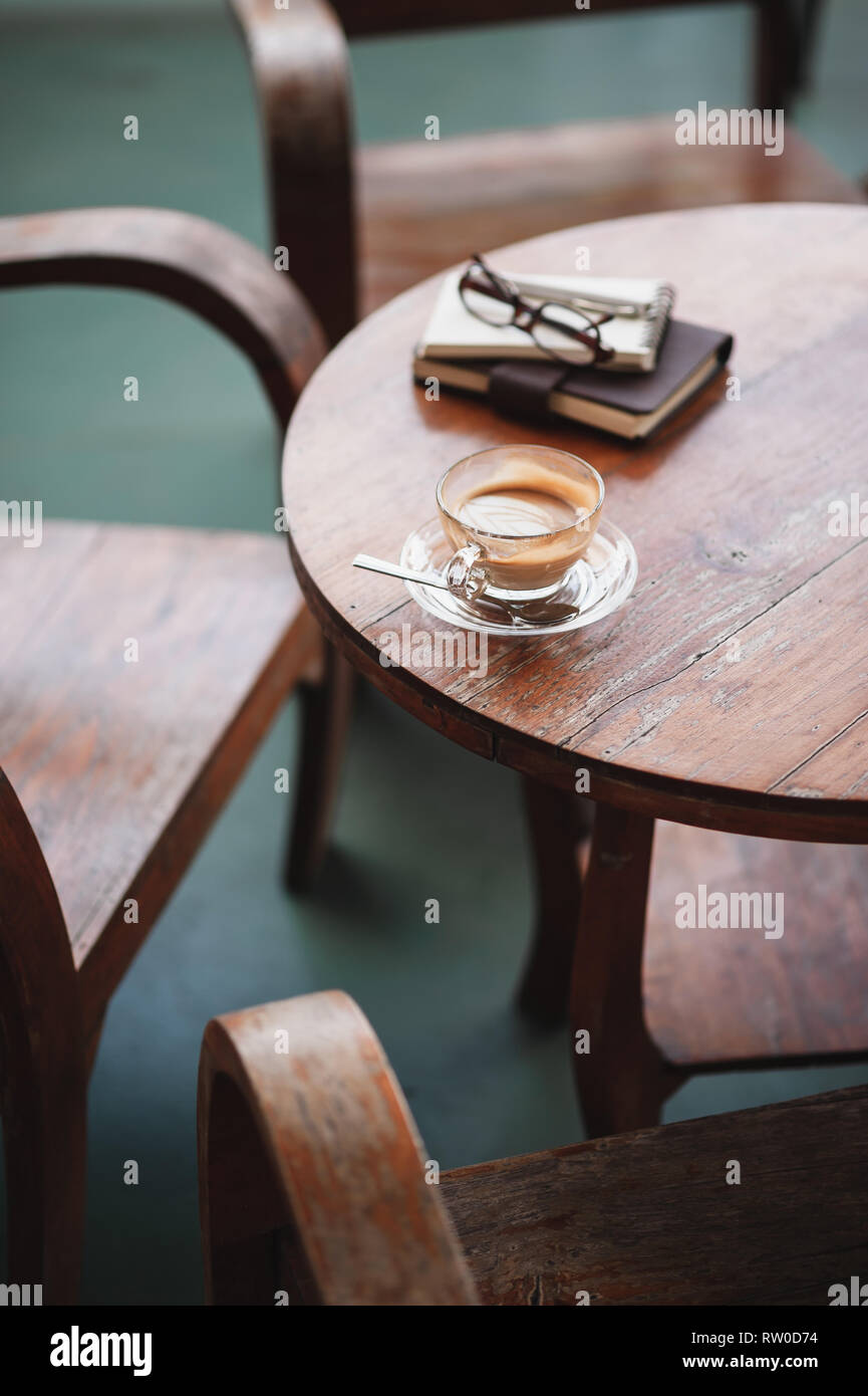 Scena astratta della tazza di caffè e i notebook su tavola in legno rustico. Coffee break e relax il tempo. Lavorare da qualsiasi concetto. Foto Stock