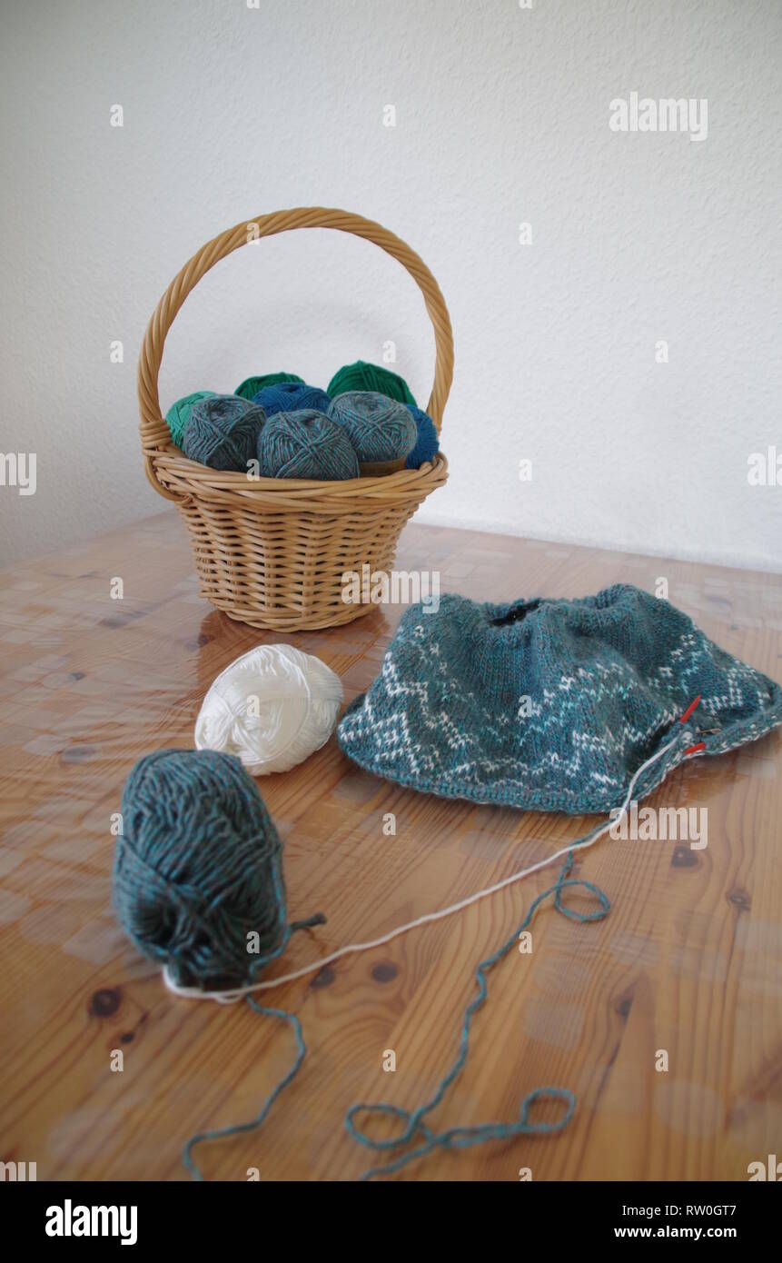 Cestello con palline di lana e maglia pullover nel lavoro Foto Stock
