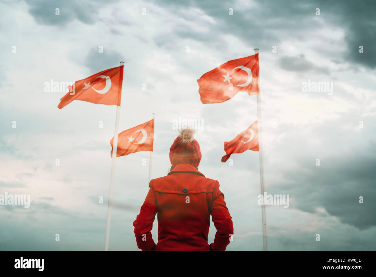 Giovane donna alla ricerca nazionale turca e bandiera sventola nel cielo Foto Stock