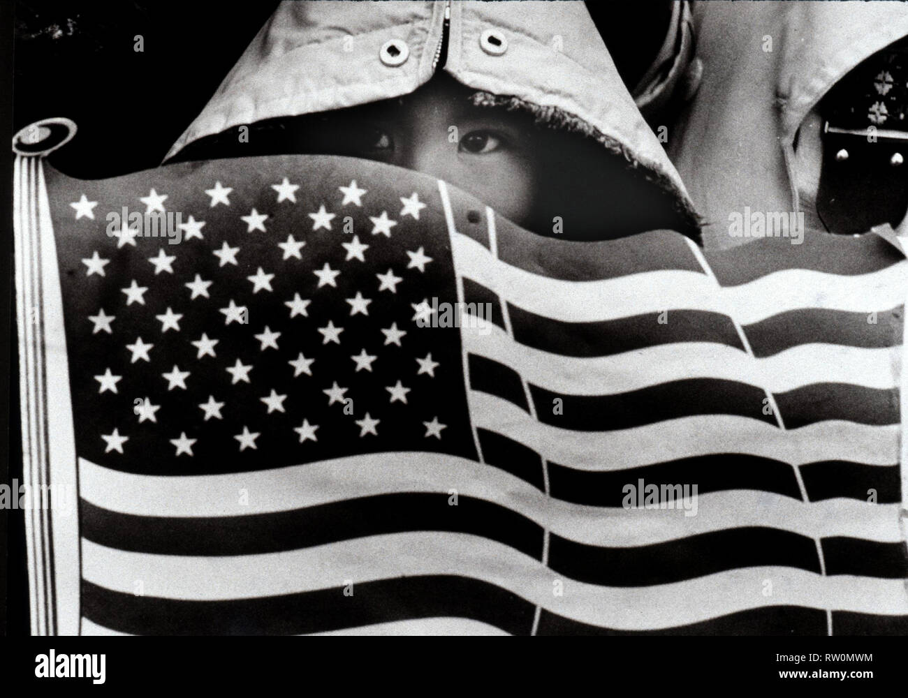 Giovane vietnamita bambino tiene una bandiera americana intaglio whle guardando un novembre undicesimo veteranâ€™s parata del giorno in Dallas TX USA FOTO DI bill belknap 1985 Foto Stock