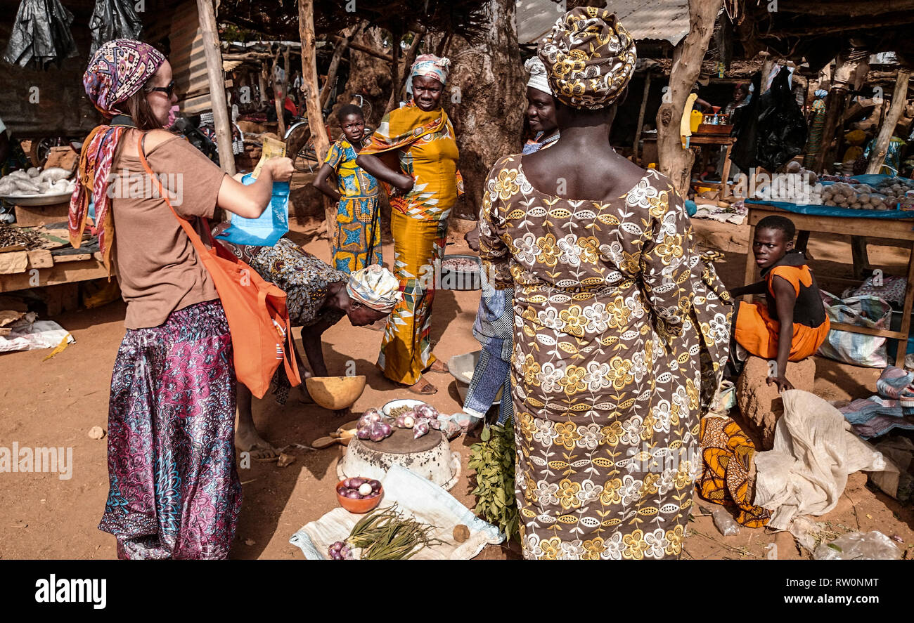 Un turista europeo acquisto di frutti e legumi provenienti da fornitori locali presso il mercato degli agricoltori in Kongo village, Ghana, Africa occidentale Foto Stock