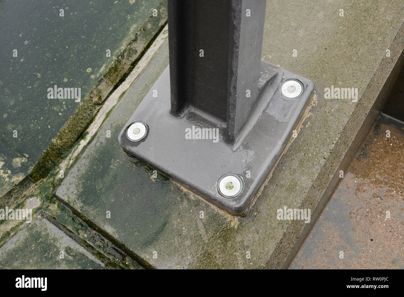 Supporto del corrimano in acciaio resistente alla corrosione imbullonato ad angolo con il calcestruzzo in caso di intemperie ad Anchorsholme, Blackpool, sulla costa di fylde nel lancashire uk Foto Stock
