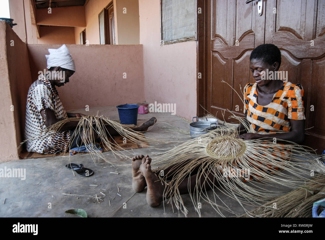 Una foto di due locali di donne ghanesi di tessitura del famoso Bolga (Bolgatanga) intrecciato cestini di mercato in casa loro a Kongo village, Ghana. Foto Stock