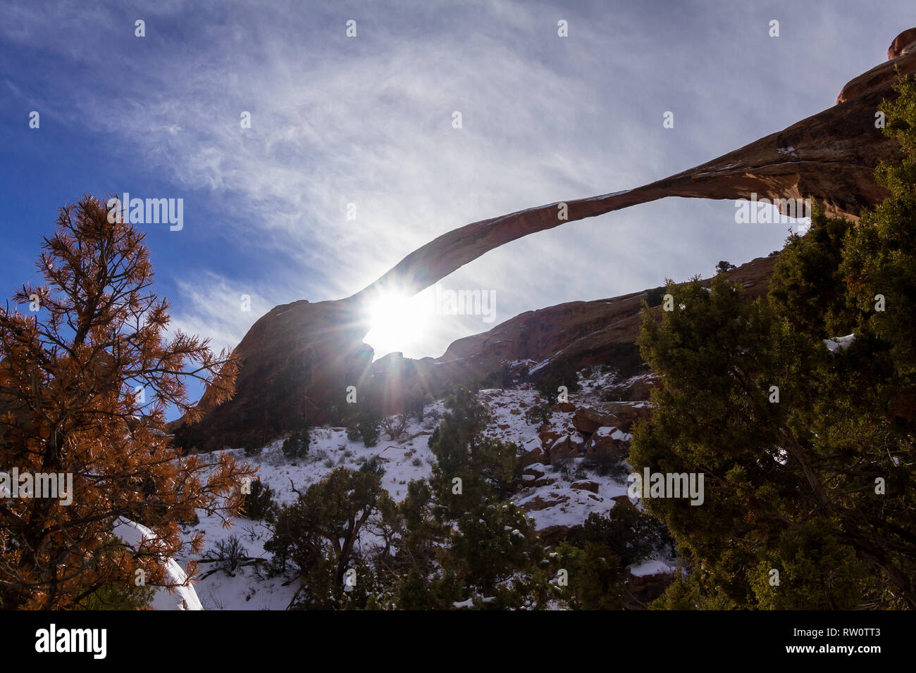 Scena invernale di Landscape Arch con il sole a picco attraverso l'angolo e un po' di neve in zone ombreggiate Foto Stock