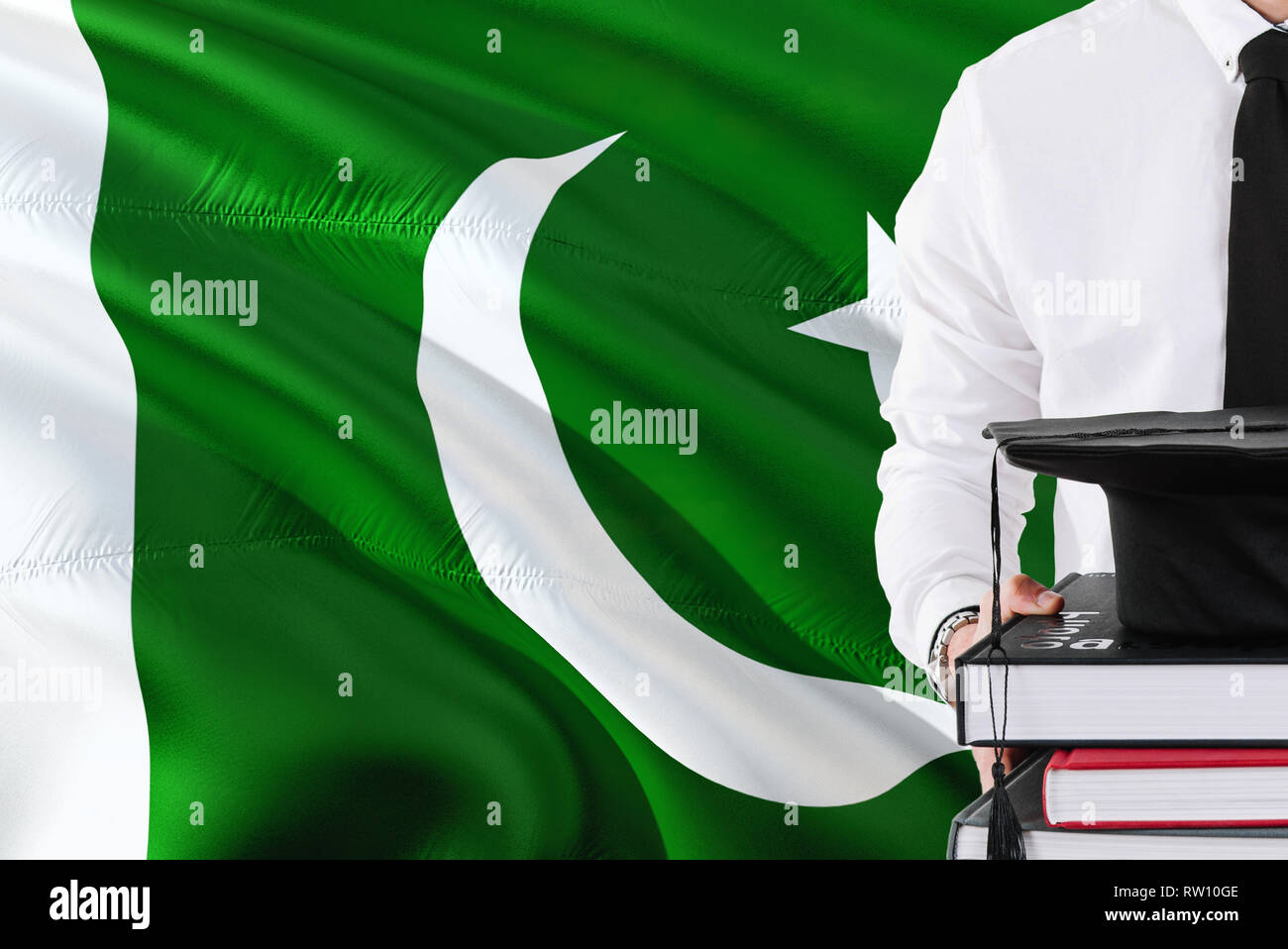 Il successo dello studente pakistano il concetto di istruzione. Contenere libri e graduazione tappo sopra il Pakistan bandiera dello sfondo. Foto Stock