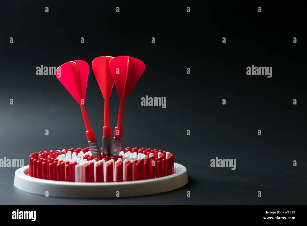 Dartboard con tre frecce dart di colpire il centro Foto Stock