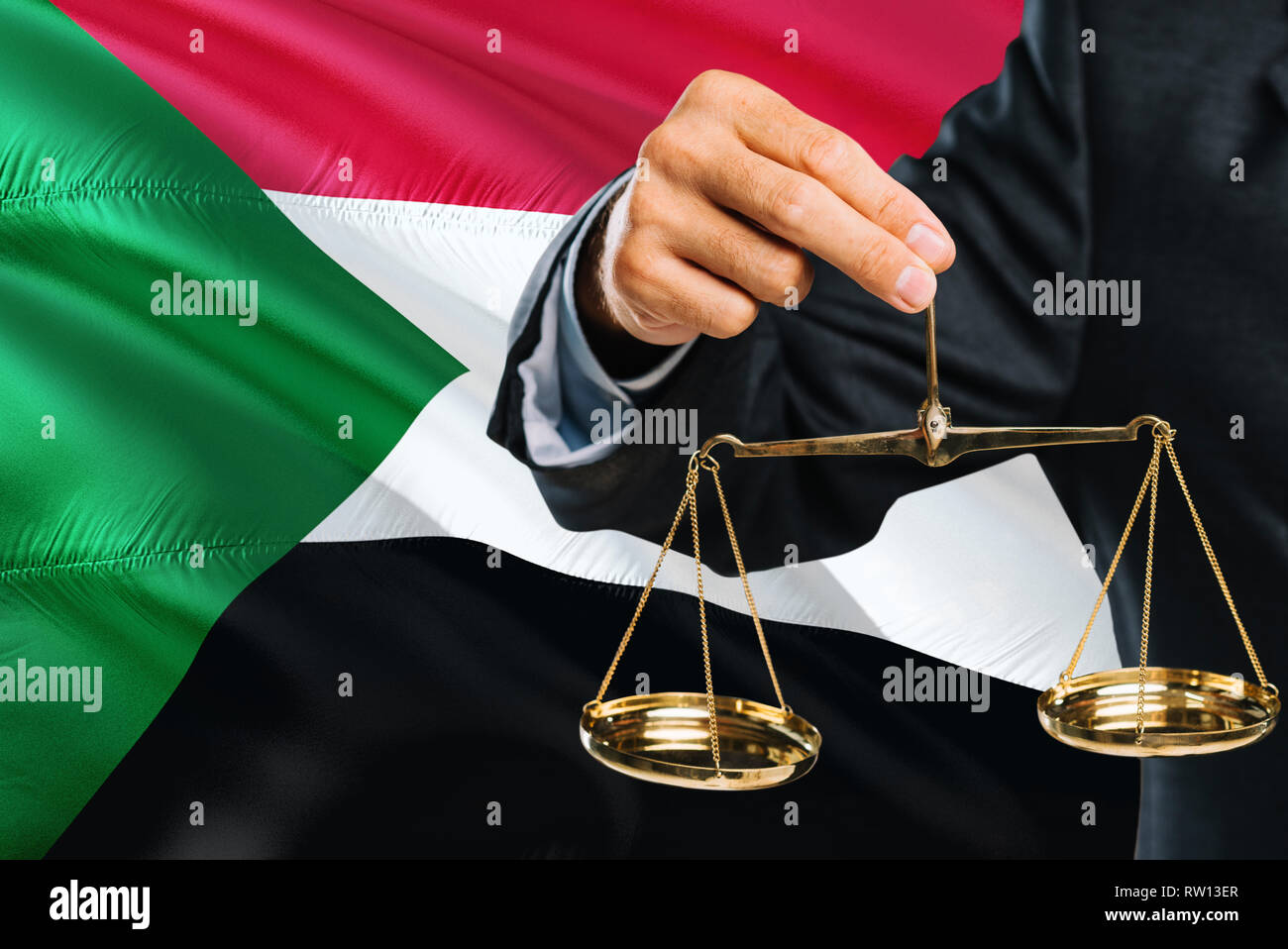 Giudice sudanese è azienda golden scale di giustizia con il Sudan sventola bandiera dello sfondo. Tema di uguaglianza e di concetto giuridico. Foto Stock