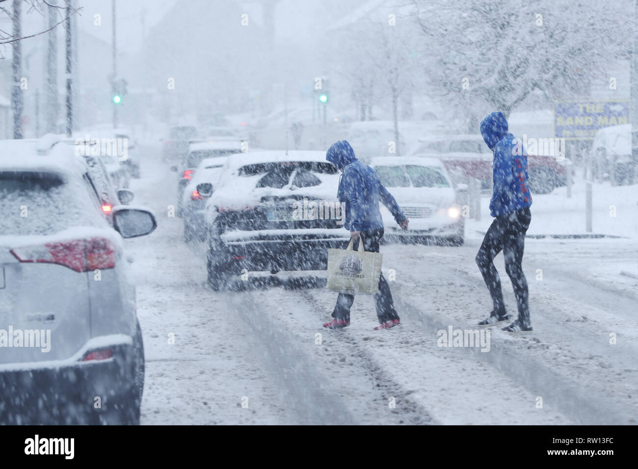 La gente a piedi nella neve in Rathcoole a Dublino. Foto Stock