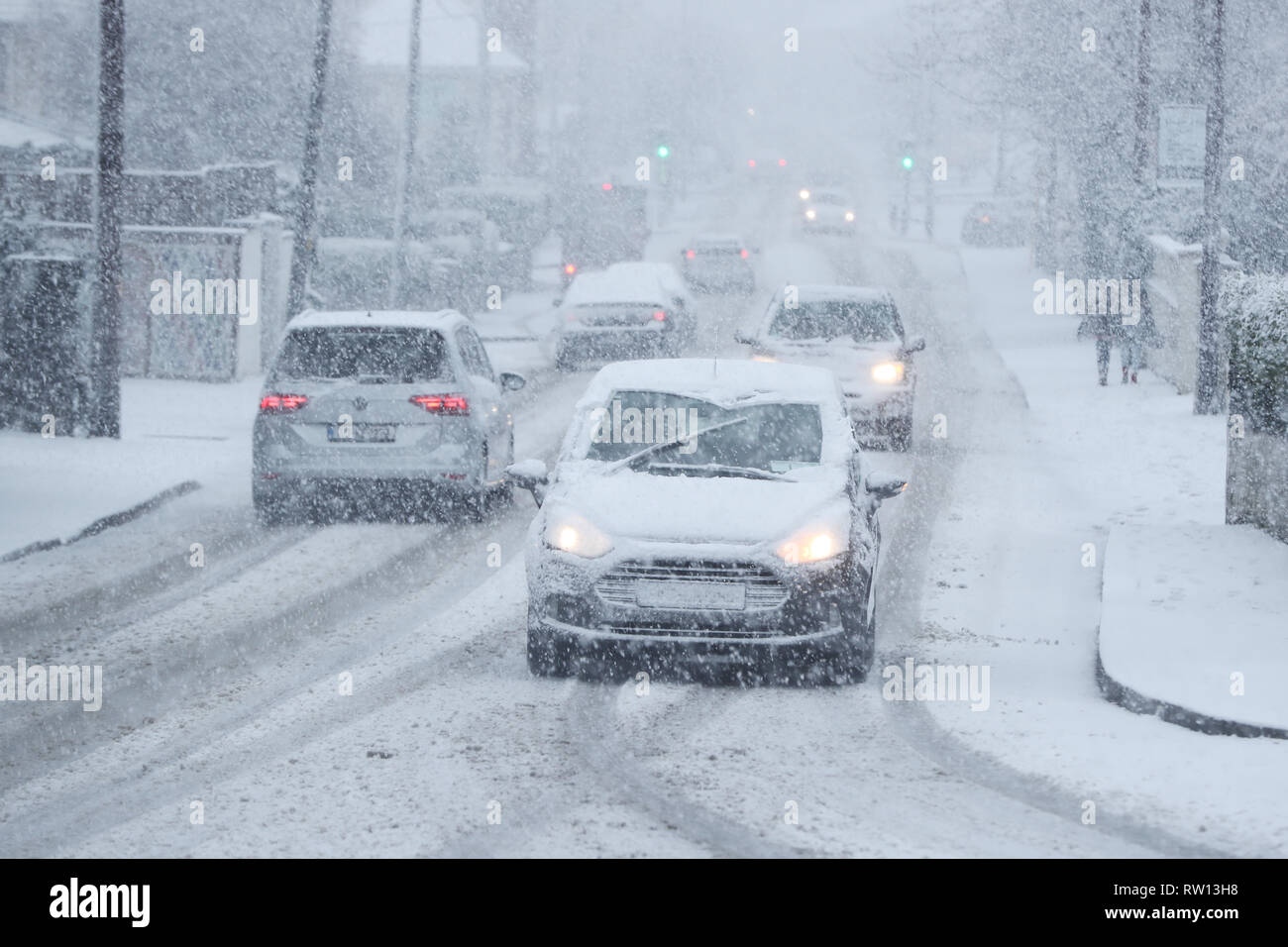 La gente guidare in condizioni di neve in Rathcoole a Dublino. Foto Stock