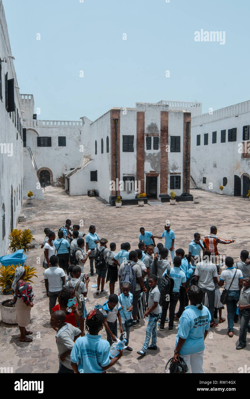 Una bella foto della locale scuola di ghana gli studenti visitando il vecchio e storico Elmina slave castello presso la costa del Ghana, Africa occidentale Foto Stock