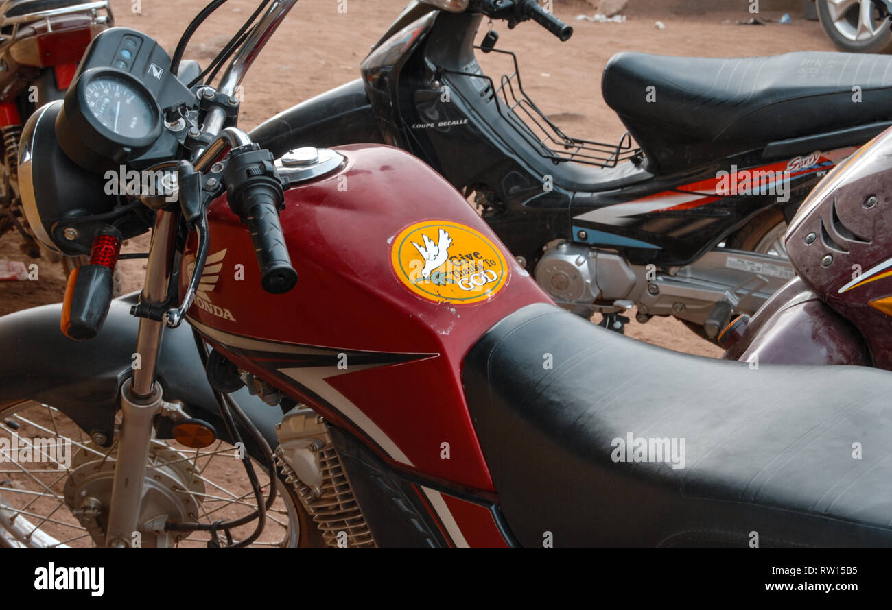 Una bella foto di un adesivo arancione su un motociclo rosso con il segno religioso rendiamo grazie a Dio. Foto Stock