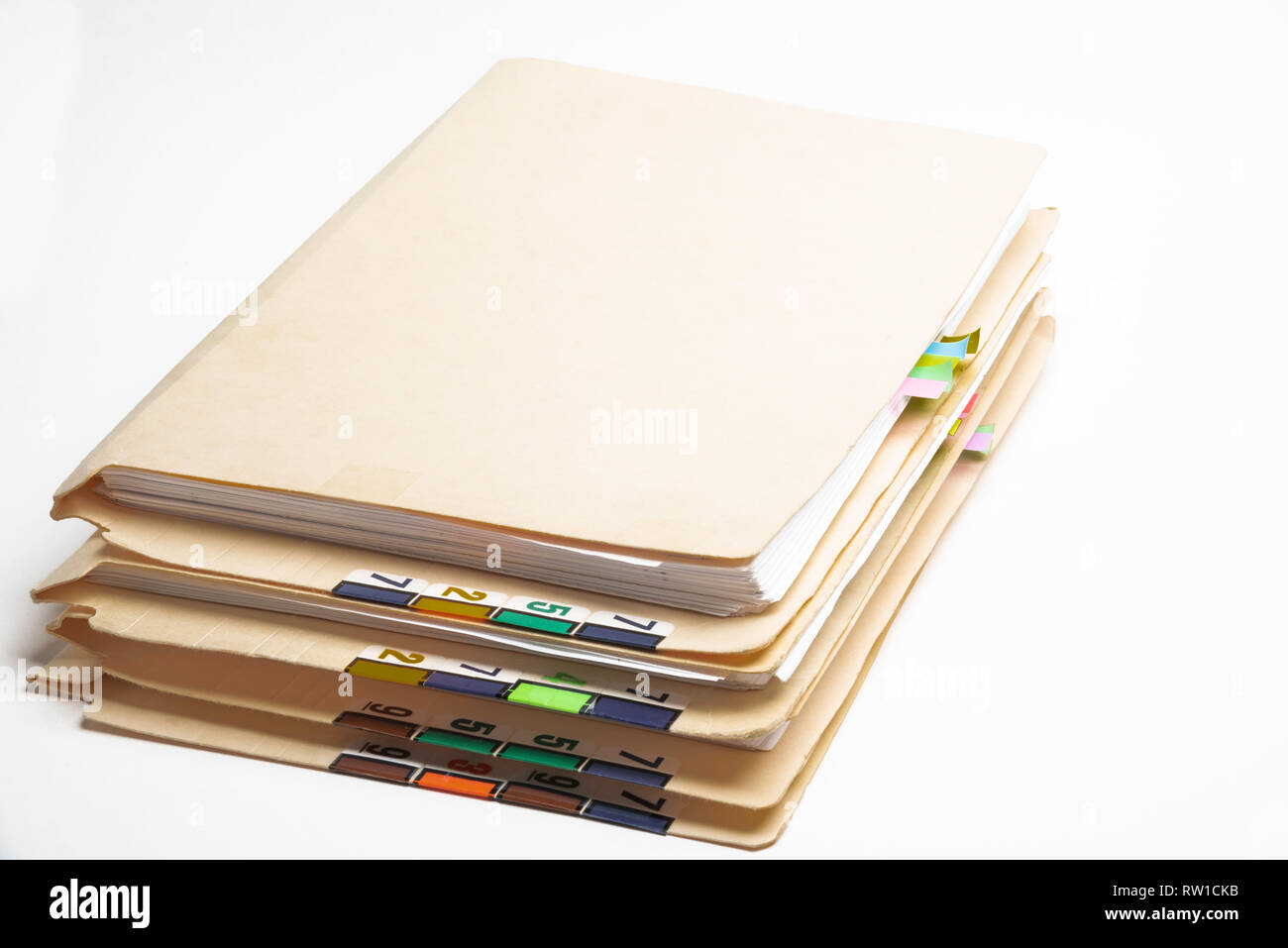 Una pila di paziente medical records in cartelle con colori codificati e schede numerate. Foto Stock