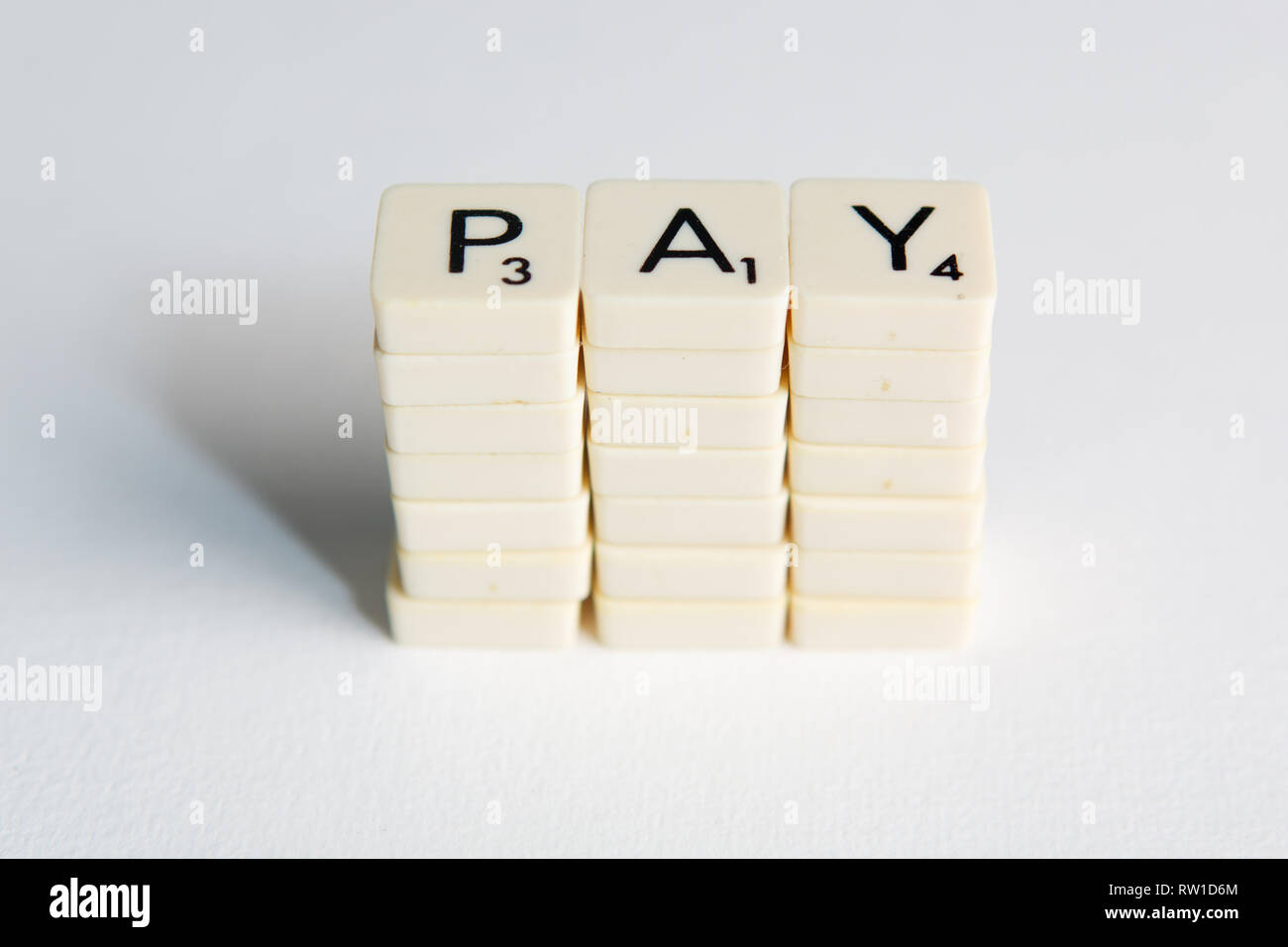 Piastrelle scrivi la parola "pagare" che rappresenta un aumento di stipendio Foto Stock