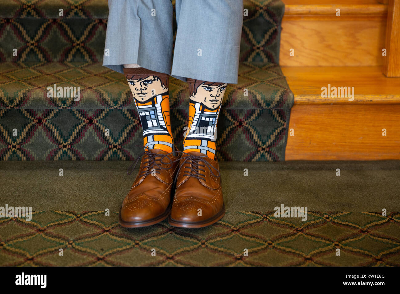 Lo sposo il giorno del matrimonio che mostra uno stile Luke Skywalker-tema calze marrone con scarpe e pantaloni grigi Foto Stock