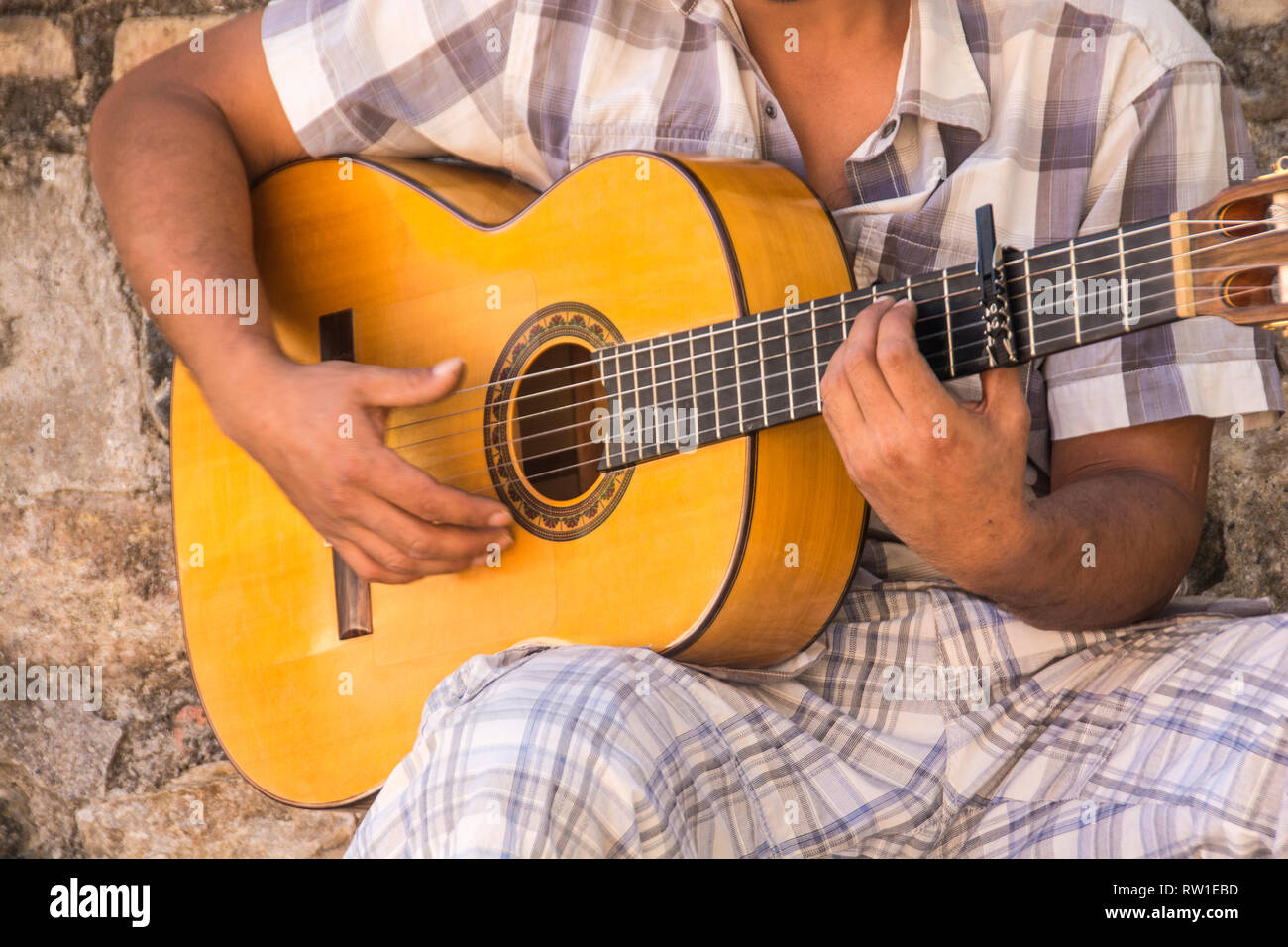 Un giovane uomo di suonare la chitarra flamenco in un allyway somewehre nella città vecchia di Albaicin, Granada, Spagna. Foto Stock